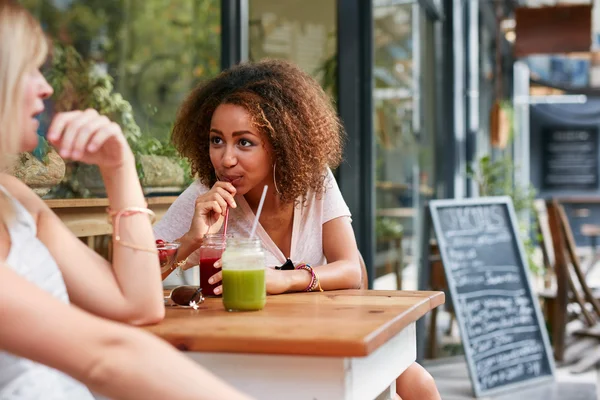 Female friends meeting at sidewalk cafe