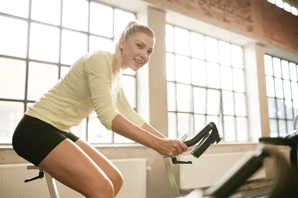 Sportive woman working out on exercise bike