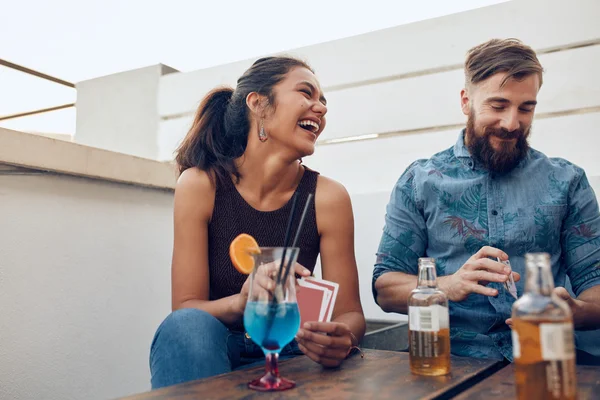 Happy young couple playing cards during a party