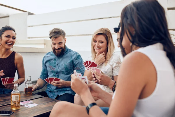 Young people playing a game of cards during a party