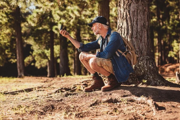 Hiker using a compass in the forest for navigation