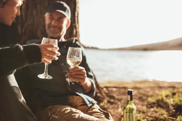Senior couple drinking wine while camping
