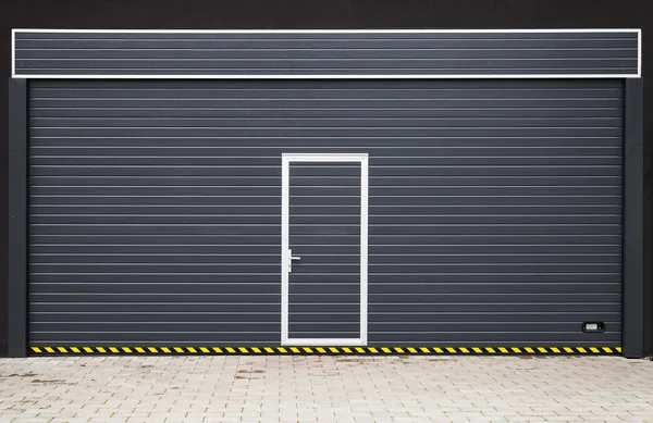 Dark gray modern garage gate with small door