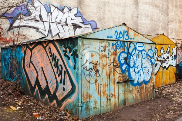 Old rusted locked garages with grungy graffiti