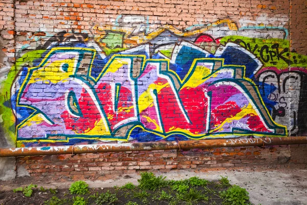 Colorful abstract graffiti text pattern on brick wall