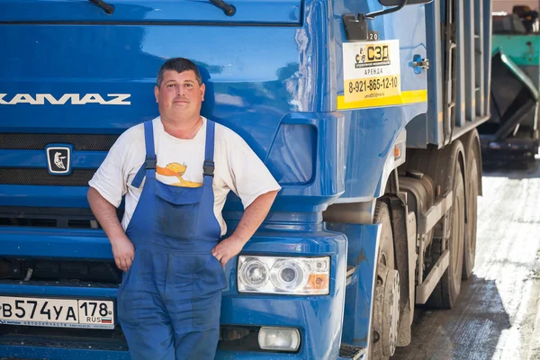 Positive truck driver stands near his Kamaz