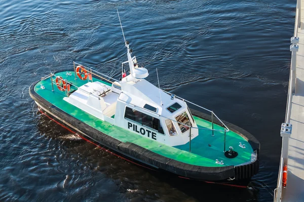 Small pilot boat with green deck and black hull