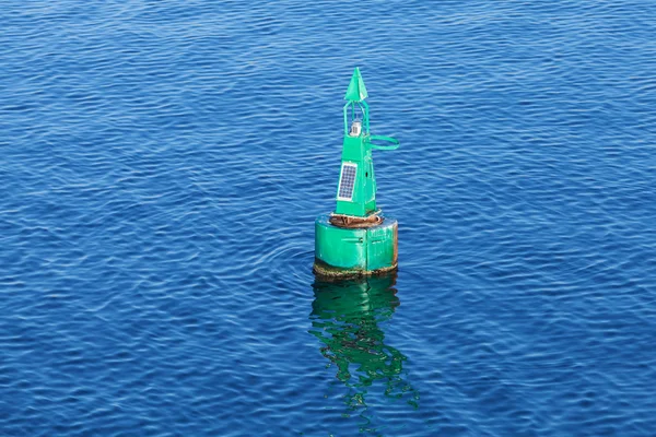 Green modern navigation buoy on sea water