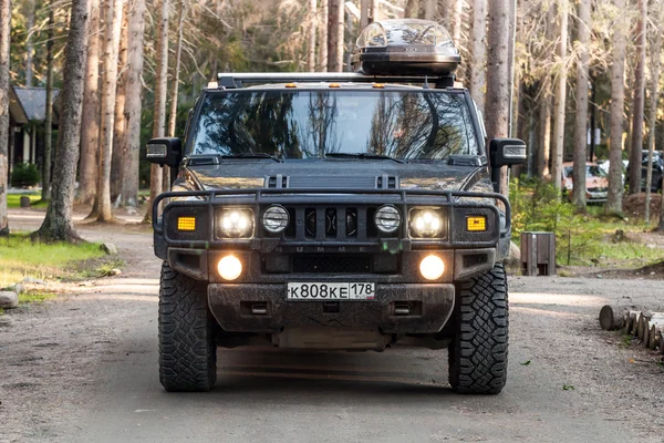 Black Hummer H2 vehicle goes on dirty country road