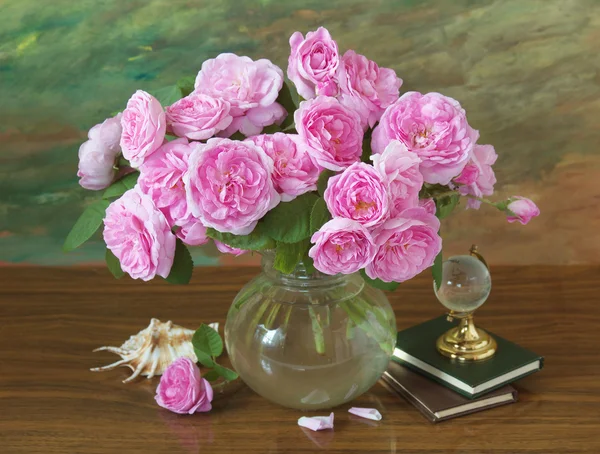 Still life with roses flowers, books, globe and sea shell on artistic background