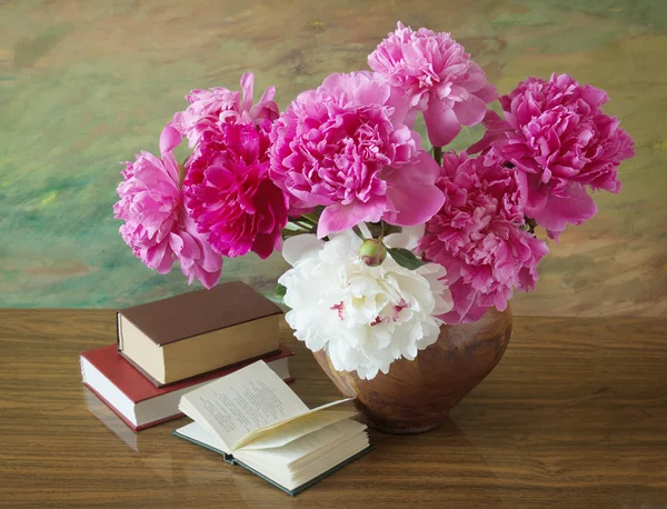 Still life with peony flowers and books on artistic background
