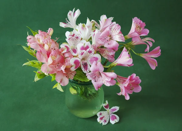 Still life with beautiful pink flowers in vase on artistic background. Alstroemeria bunch