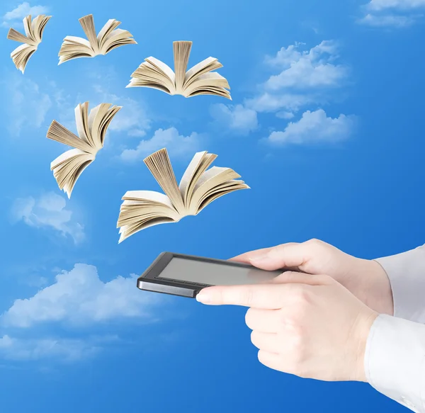 Hand holding electronic book and opened books flying away (education concept)