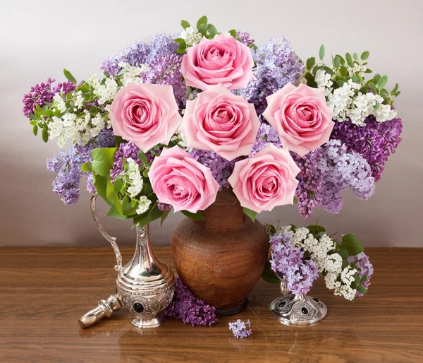 Still life with huge bunch of roses, lilac flowers on painting background