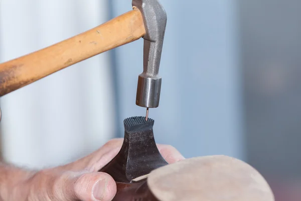 Shoemaker repairs a shoe