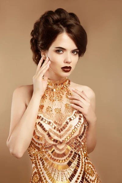 Beauty makeup. Hairstyle. Fashion woman in gold dress isolated o