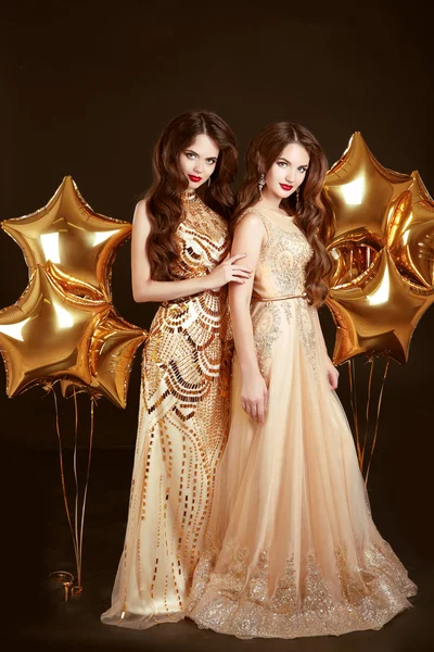 Elegant ladies on party. Beautiful sexy girls wearing in gold fa