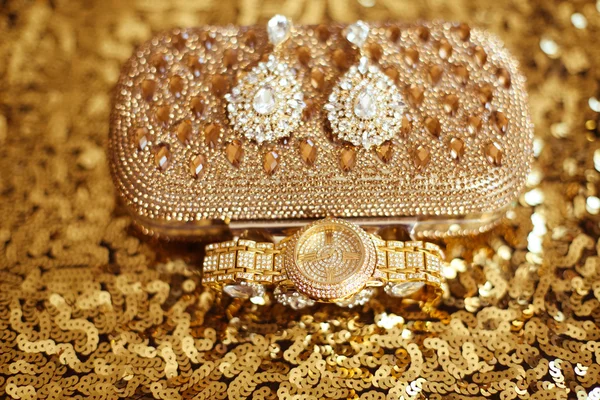 Womens accessories. Fashion diamond earrings and golden wristwat