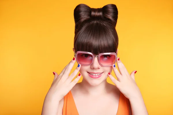 Happy smiling teen girl with fashion sunglasses, bow hairstyle a