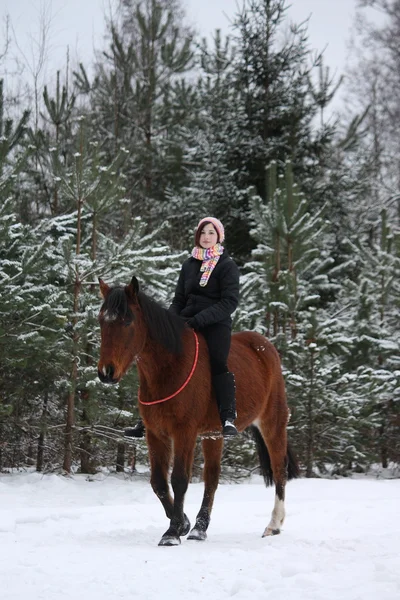 Teenager girl riding horse without saddle and bridle
