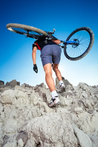 Bicycle rider crossing rocky terrain
