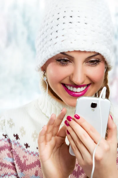 Winter girl listening music using phone