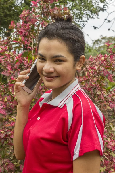 Young smiling asian woman talks on telephone