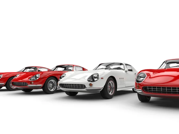 Vintage sports cars - white stands out in a row of red cars