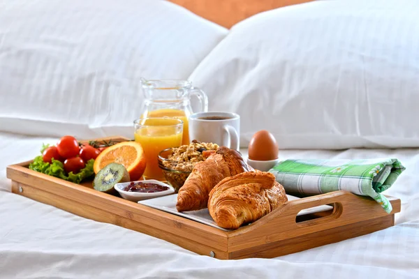 Breakfast tray in bed in hotel room