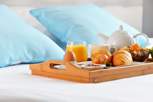 Breakfast on tray in bed in hotel room