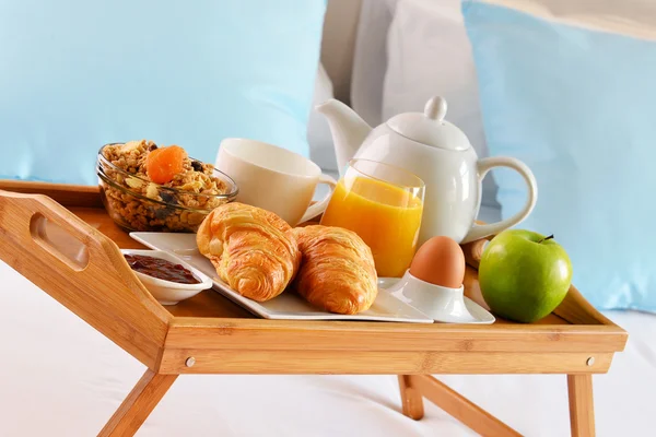 Breakfast on tray in bed in hotel room