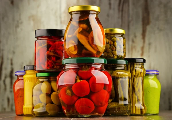 Jars with variety of pickled vegetables.