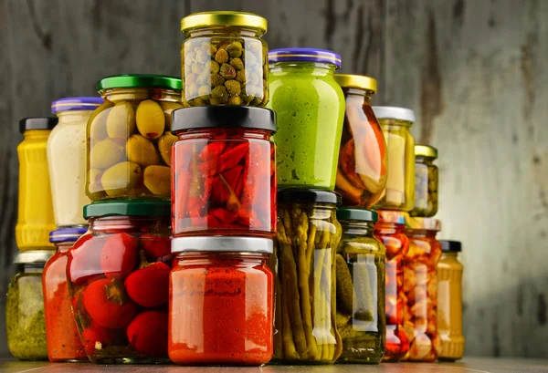 Jars with variety of pickled vegetables.