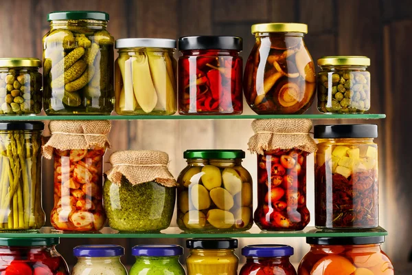 Jars with variety of pickled vegetables.