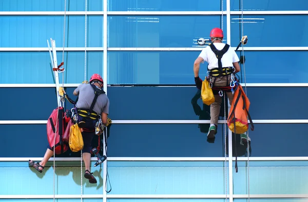 Two construction workers working at height on skyscraper