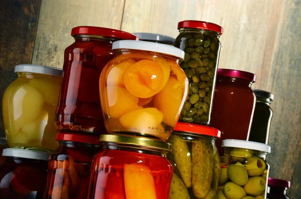 Jars with pickled vegetables, fruity compotes and jams