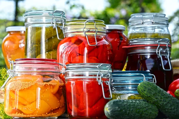 Jars of pickled vegetables and fruits in the garden