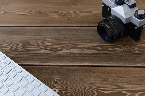 Camera and keyboard on a dark desk background