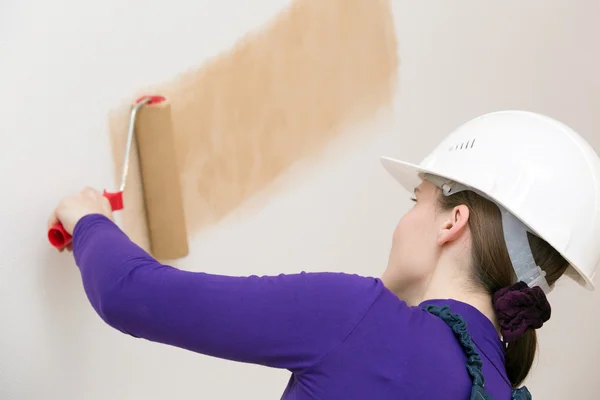 House painter worker drawing wallpaper with painting roller