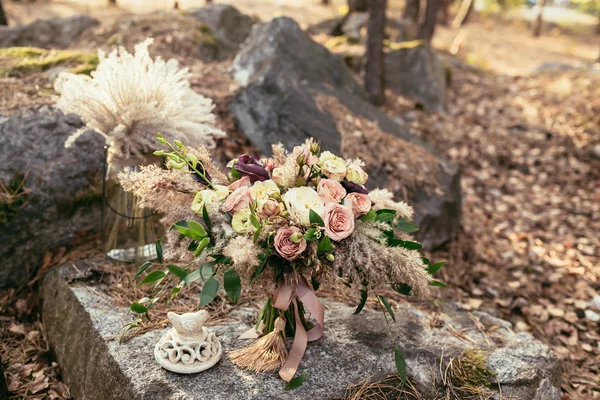 Wedding. Newlyweds. Bridal bouquet. The groom in a suit and the bride hands with a bouquet of pink flowers and greenery