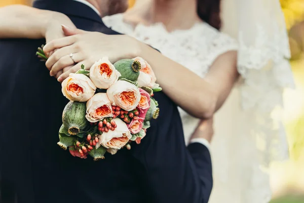 Bride hug groom with wedding bouquet