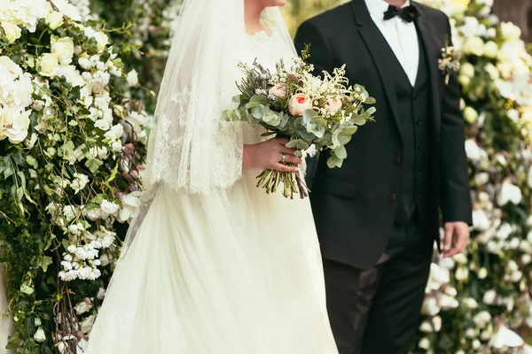 Groom in black suit and bride in white wedding dress with rustic