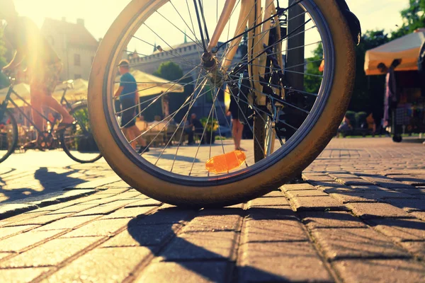The wheel of a parked bicycle on Livu square in Riga against the