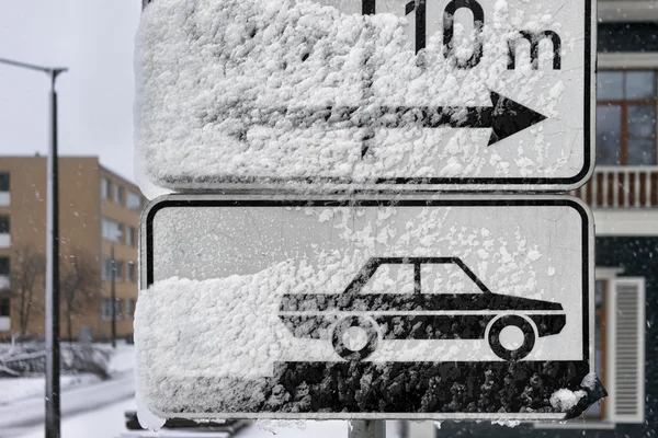 Road signs parking on the street under snow in winter