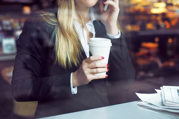 Business woman on coffee shop having break drinking coffee and talking on the phone