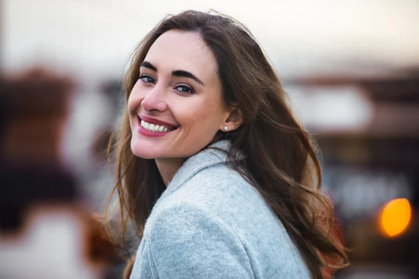 Close-up portrait of beautiful caucasian woman with charming smile walking outdoors