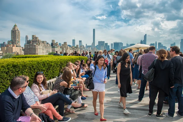 New York City - May 14, 2016: People chilling on rooftop party with Manhattan and Central Park view of the Metropolitan Museum of Art in New York.