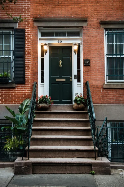 Front Door of a Beautiful Georgian Era English Manhattan Town House. New York City home building entrance with green door and steps