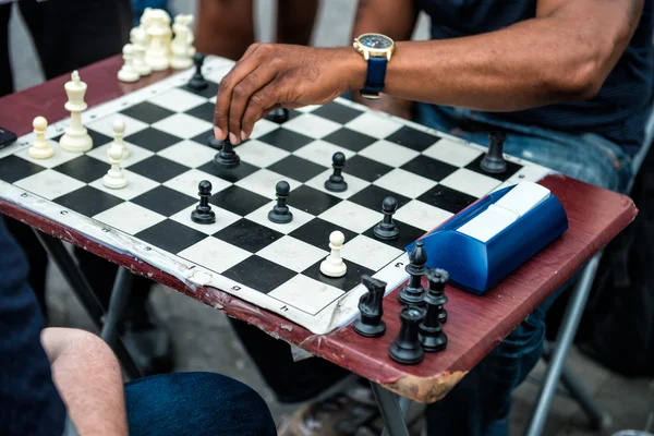 Close up of hands of people playing quick chess on the street with timer. Chess street tournament.