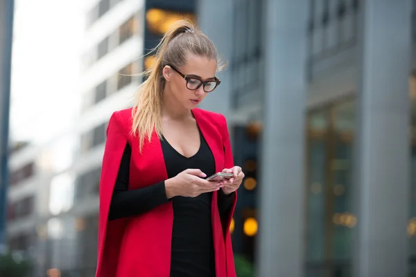 Business woman texting on cell phone and walking around financial district area in New York City